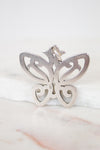 Silver butterfly pendant on a marble surface