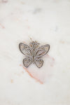 Silver butterfly pendant on a marble background