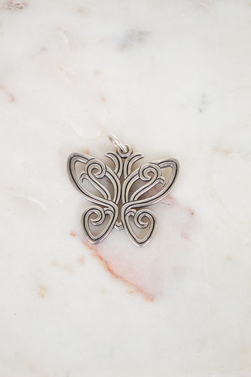 Silver butterfly pendant on a marble background