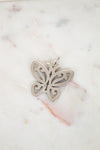 Silver butterfly pendant on a marble surface