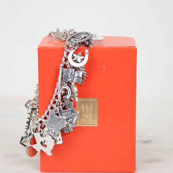 Silver charm bracelet on an orange box with a marble surface