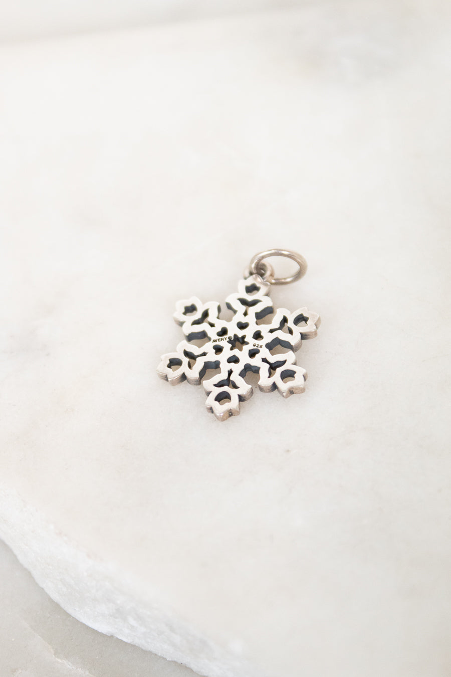 Silver snowflake pendant on a white background