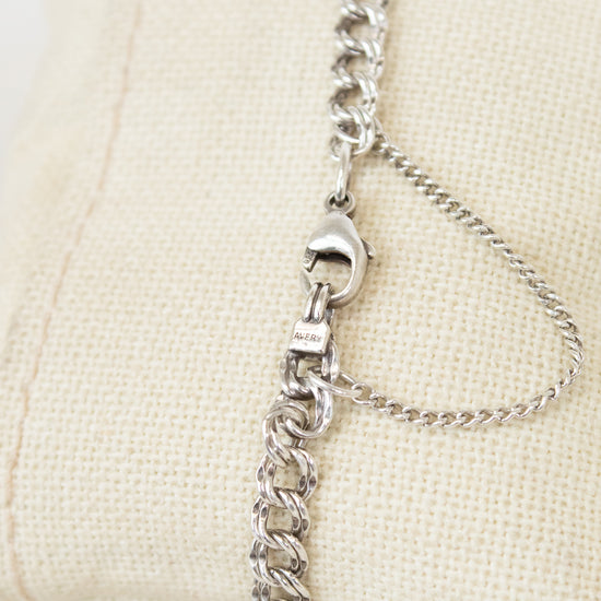 Silver chain bracelet on a beige pillow