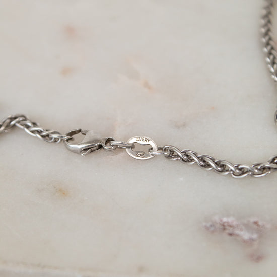 Close up of silver clasp on a marble surface