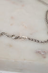Close up of silver clasp on a marble surface