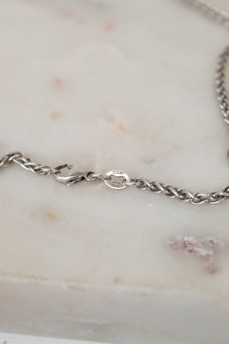 Close up of silver clasp on a marble surface