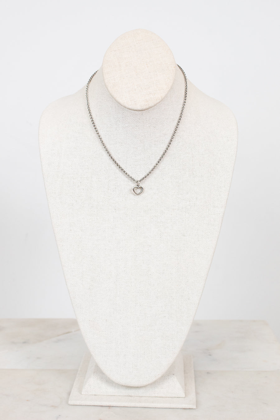Necklace on a mannequin bust against a white background