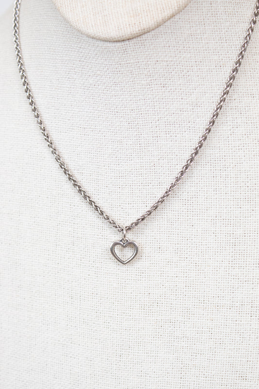 Silver necklace with a heart pendant on a light gray background
