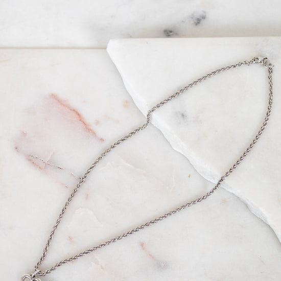 Silver necklace on a marble surface