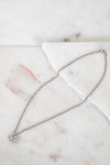 Silver necklace on a marble surface