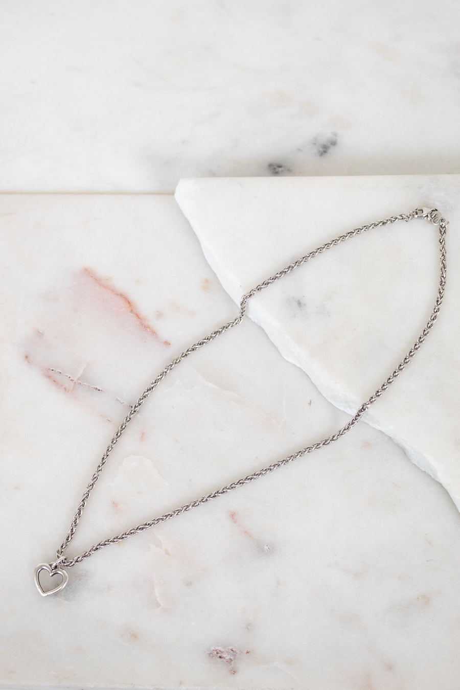 Silver necklace on a marble surface