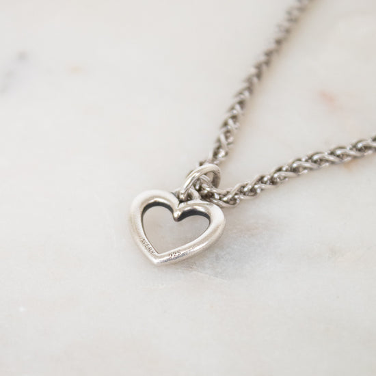Silver heart-shaped pendant necklace on a marble surface