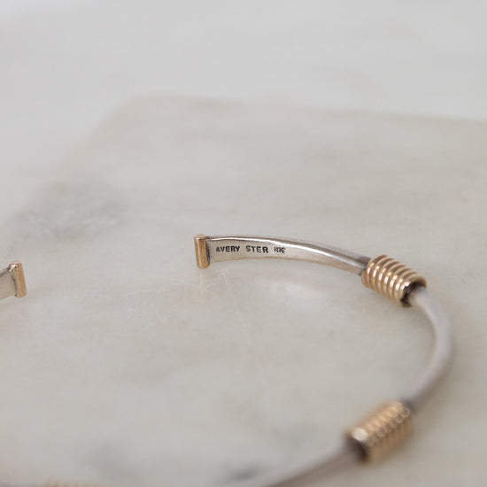 Silver and gold bracelet on a white background