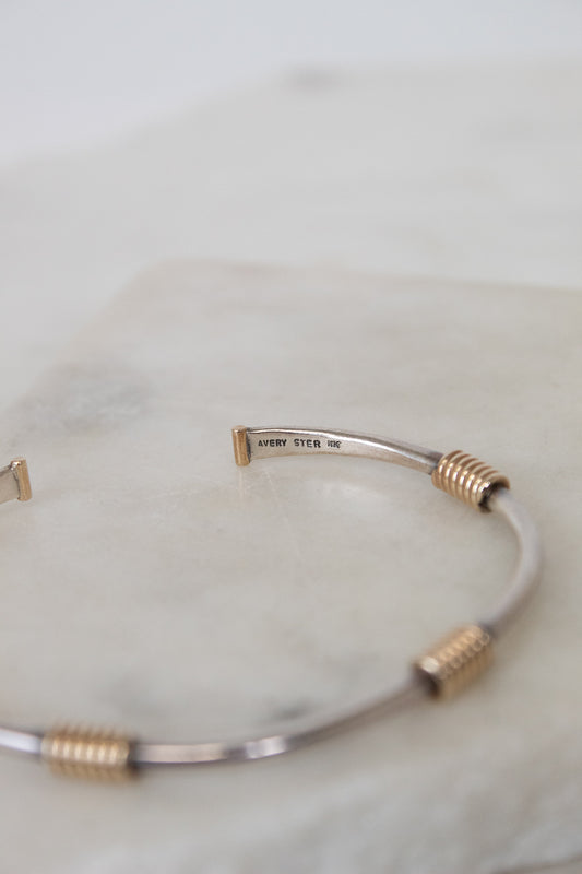 Silver and gold bracelet on a white background