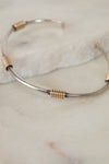 Silver and gold bracelet on a marble surface