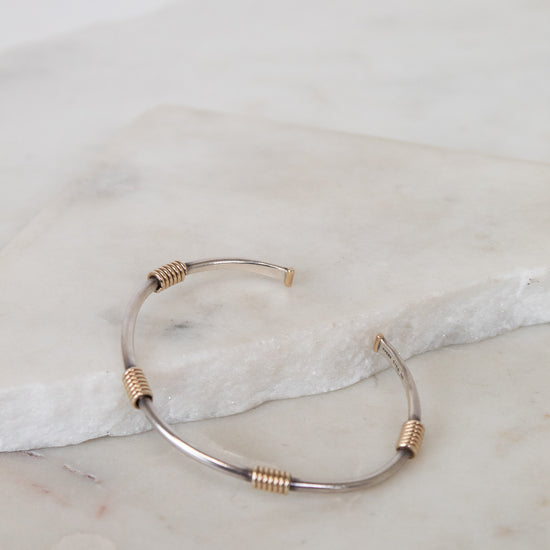 Gold and silver bracelet on a marble surface