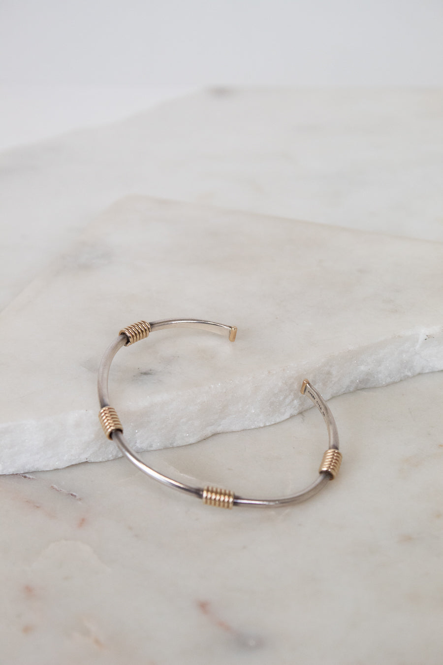 Gold and silver bracelet on a marble surface