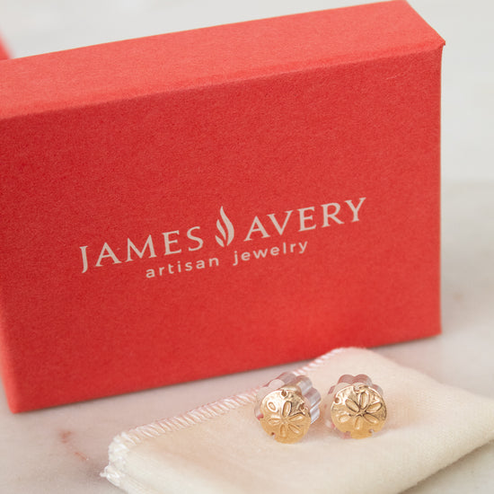 James Avery earrings on a white cloth with a red box in the background