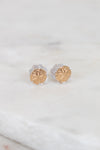Gold round stud earrings on a light background