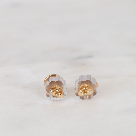 Pair of gold and clear sand dollar-shaped earrings on a white background