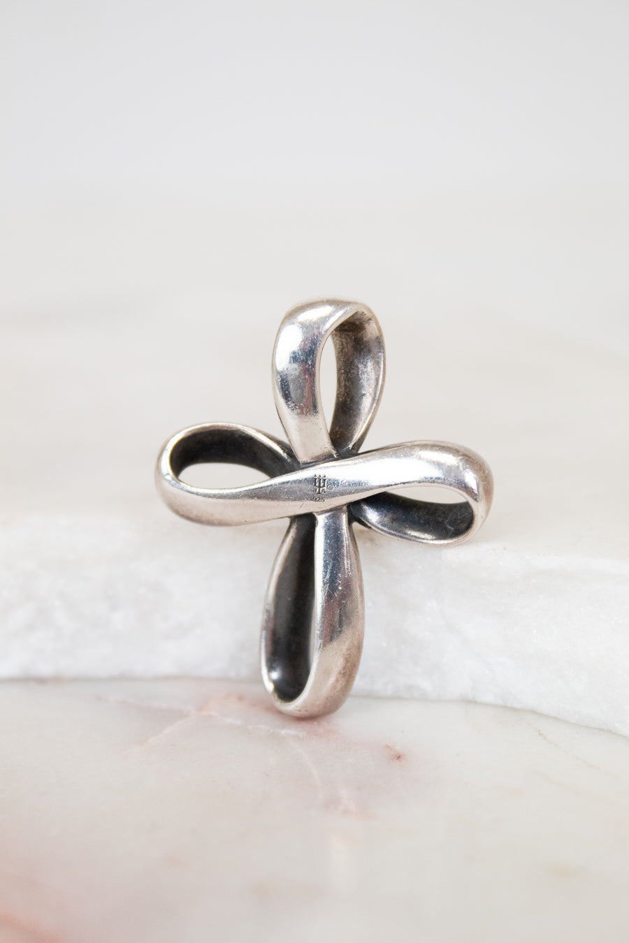 Silver cross pendant on a white background