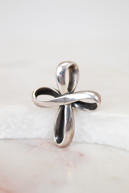 Silver cross pendant on a white background