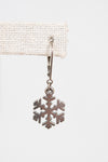 Silver snowflake charm on a white background