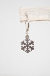 Silver snowflake earring on a white background