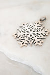 Silver snowflake pendant on a light background