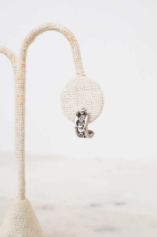 Pearl earring on a white stand with a blurred background