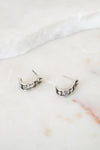 Pair of silver hoop earrings on a marble surface