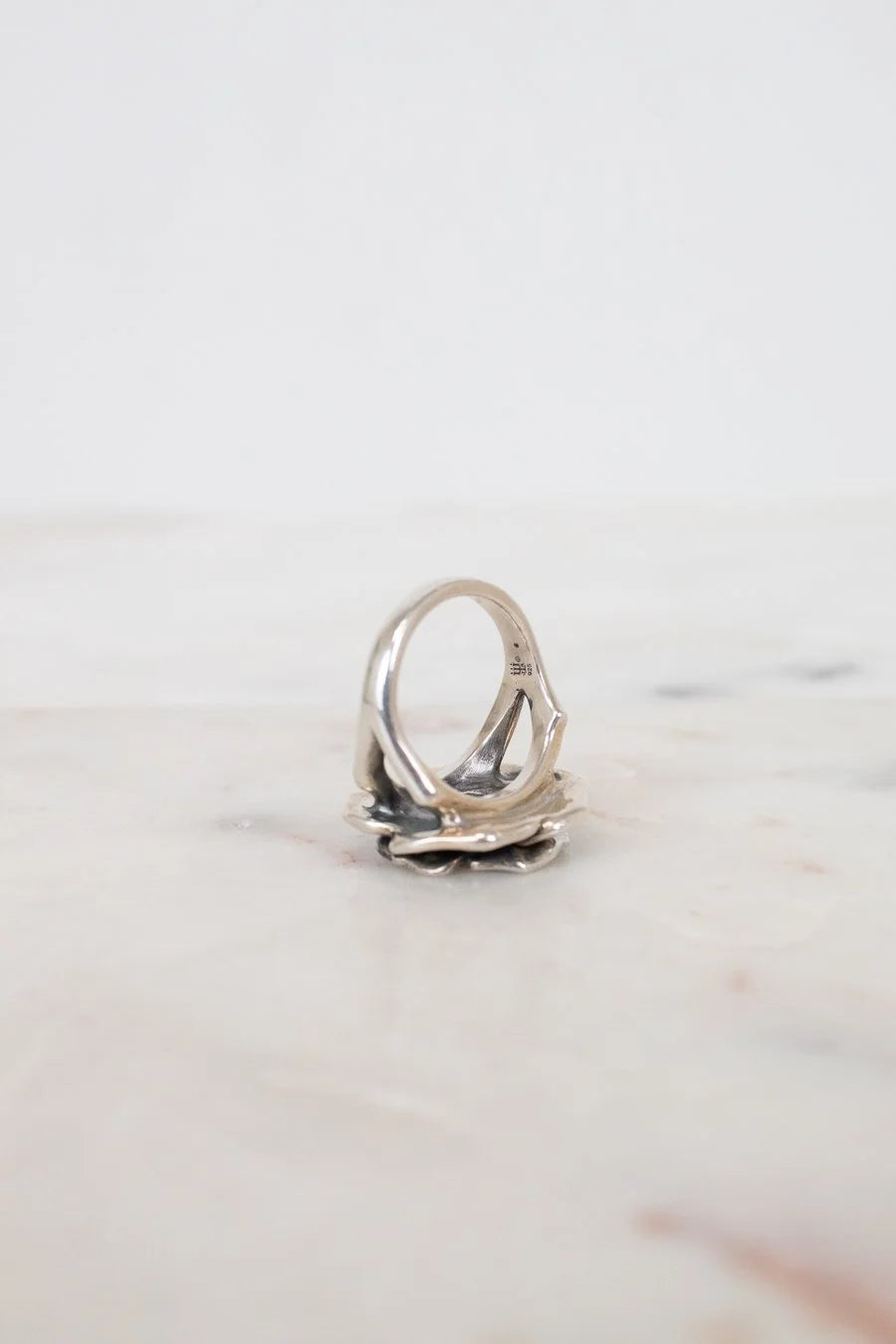 Silver ring on a light marble surface