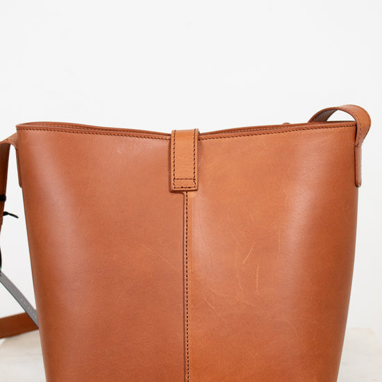 Brown leather tote bag on a light gray background