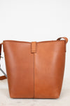 Brown leather tote bag on a light gray background