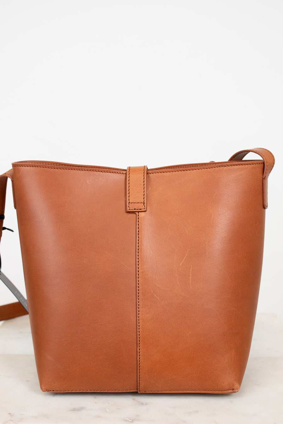 Brown leather tote bag on a light gray background