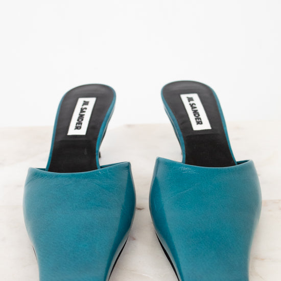 Pair of teal high-heeled shoes on a white background