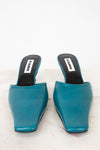 Pair of teal high-heeled shoes on a white background