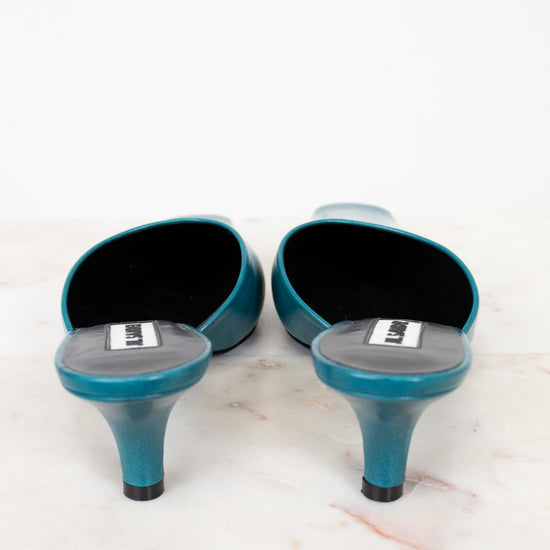 Pair of teal high-heeled shoes on a white background