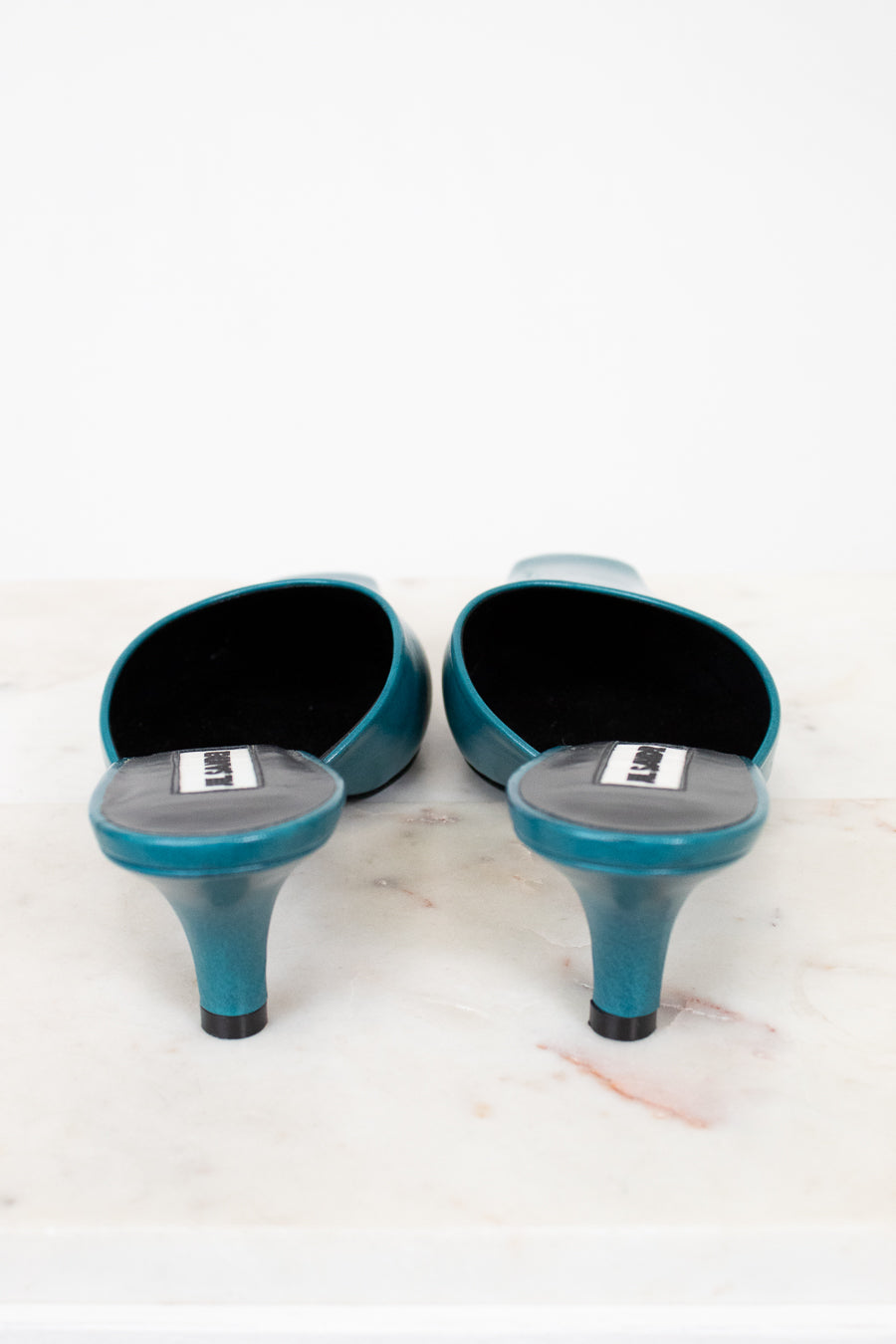 Pair of teal high-heeled shoes on a white background