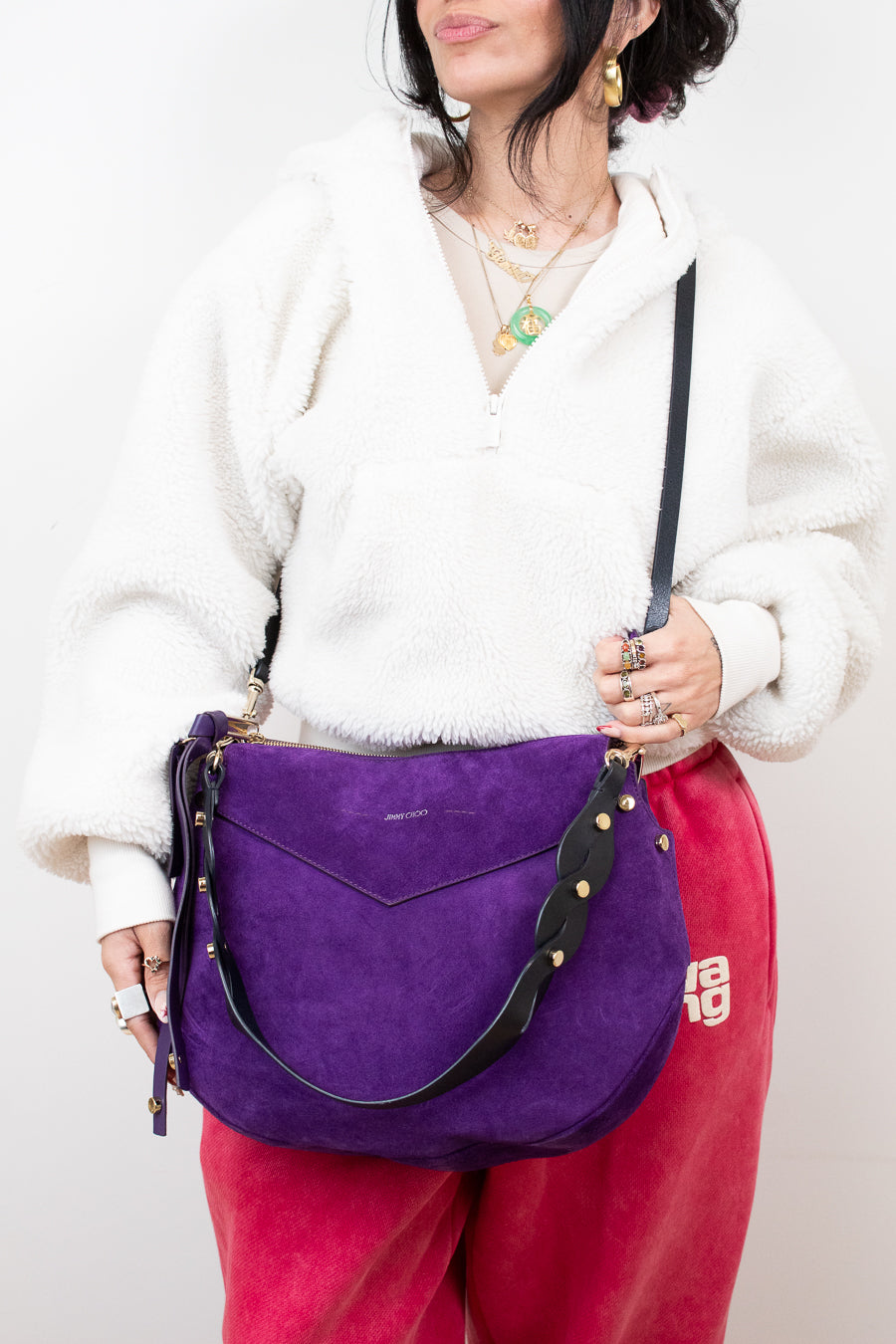 Person holding a purple handbag with a white background