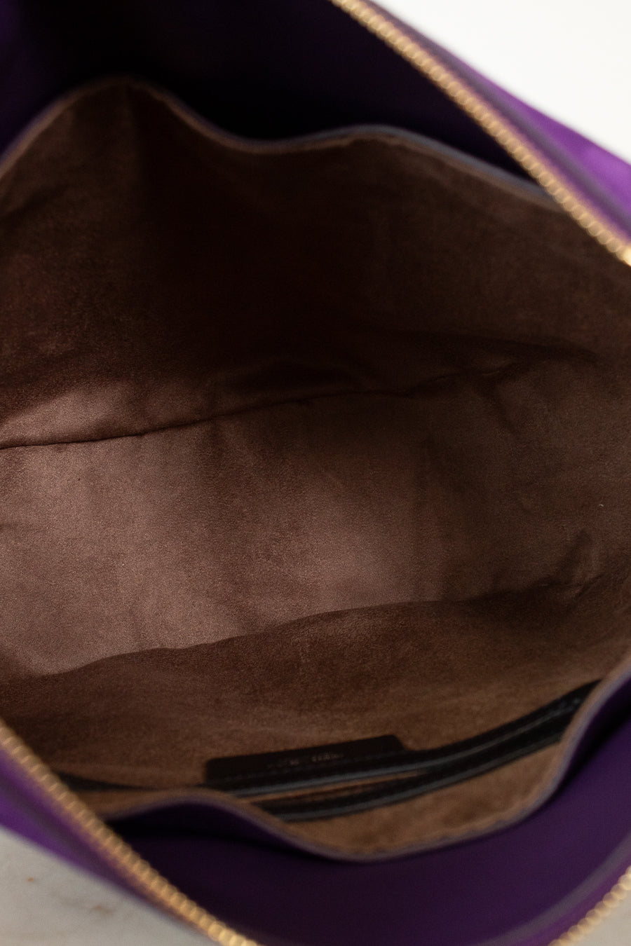 Close-up of a brown leather bag interior with a visible brand label 