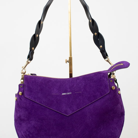 Purple handbag with black handle and gold accents on a white background