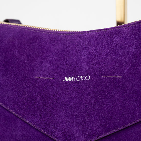 Close-up of a purple handbag with 'Jimmy Choo' branding.
