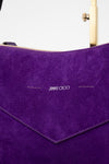 Close-up of a purple handbag with 'Jimmy Choo' branding.