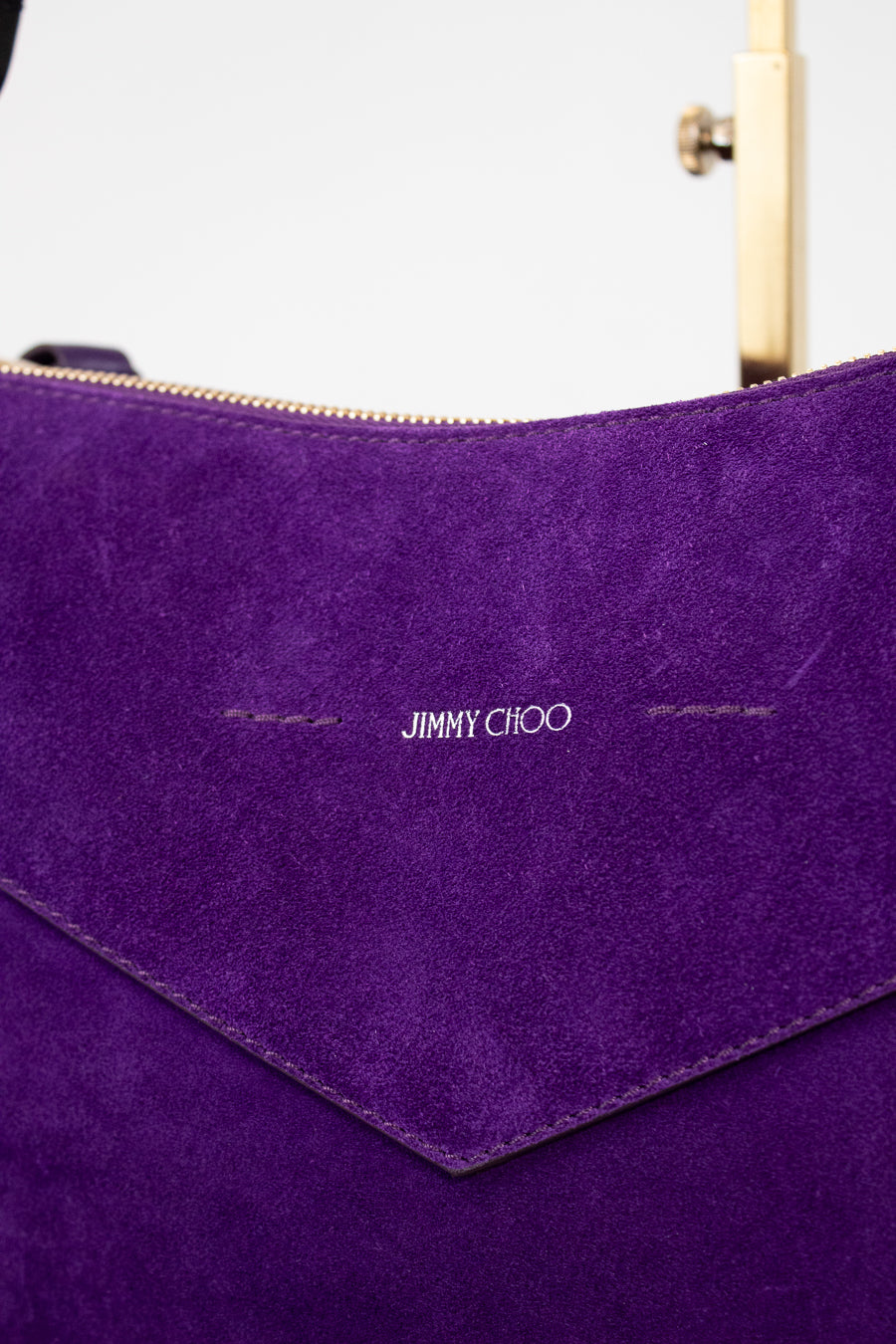 Close-up of a purple handbag with 'Jimmy Choo' branding.