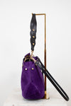 Purple handbag with a black strap on a white background