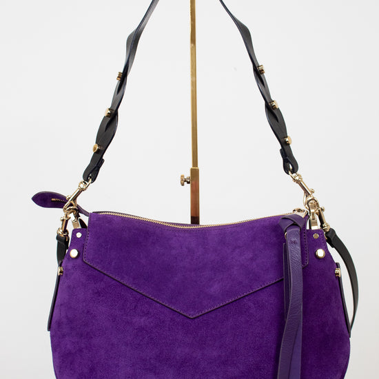 Purple handbag with black straps on a white background