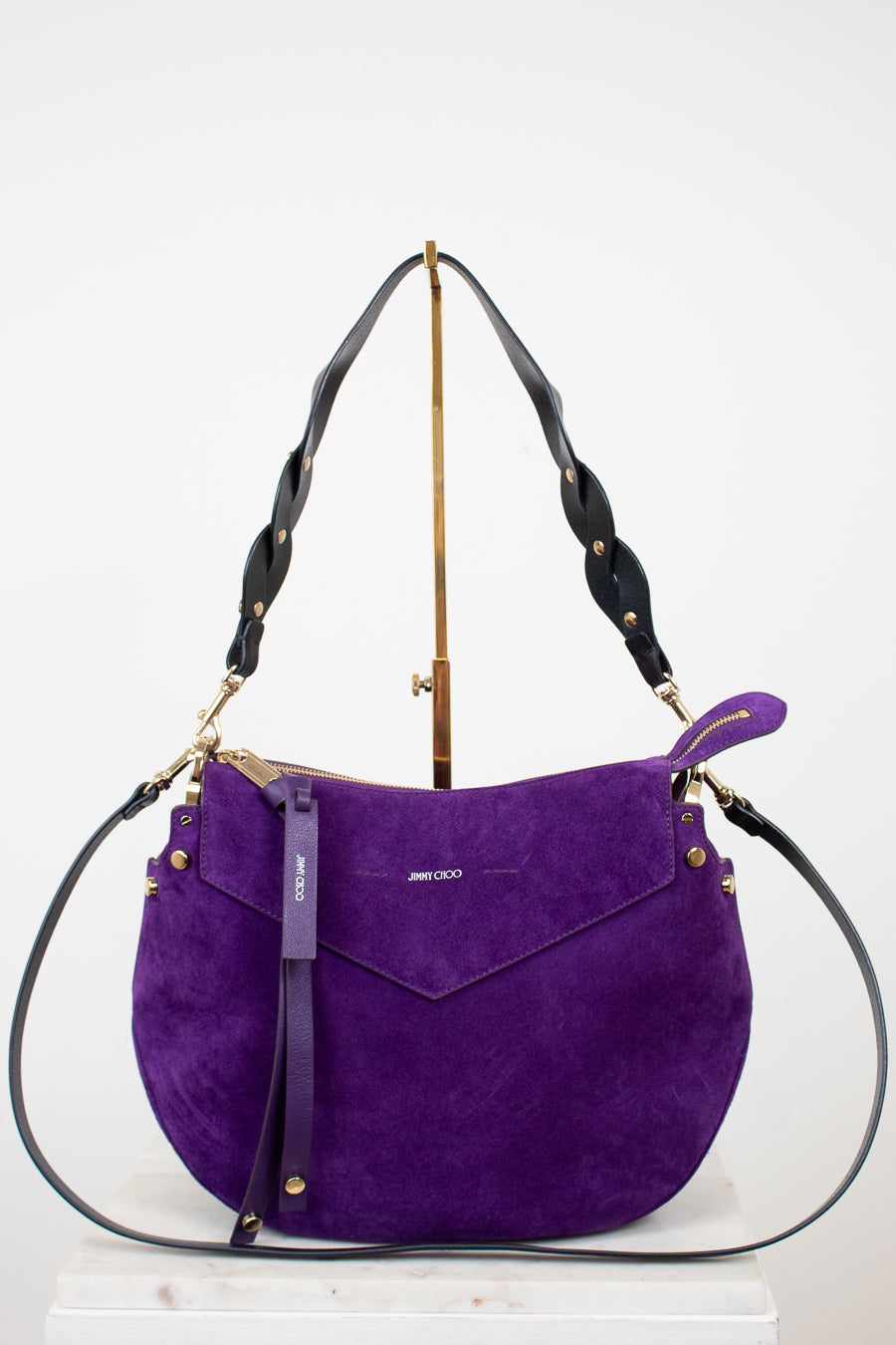 Purple handbag with gold accents on a white background