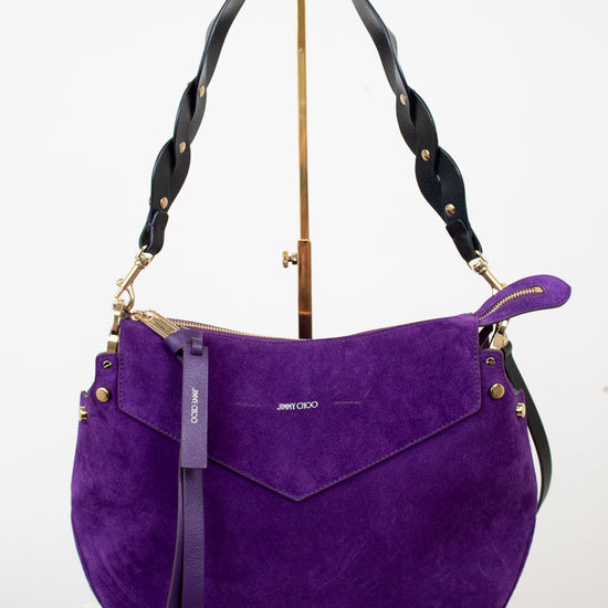 Purple handbag with black strap on a white background