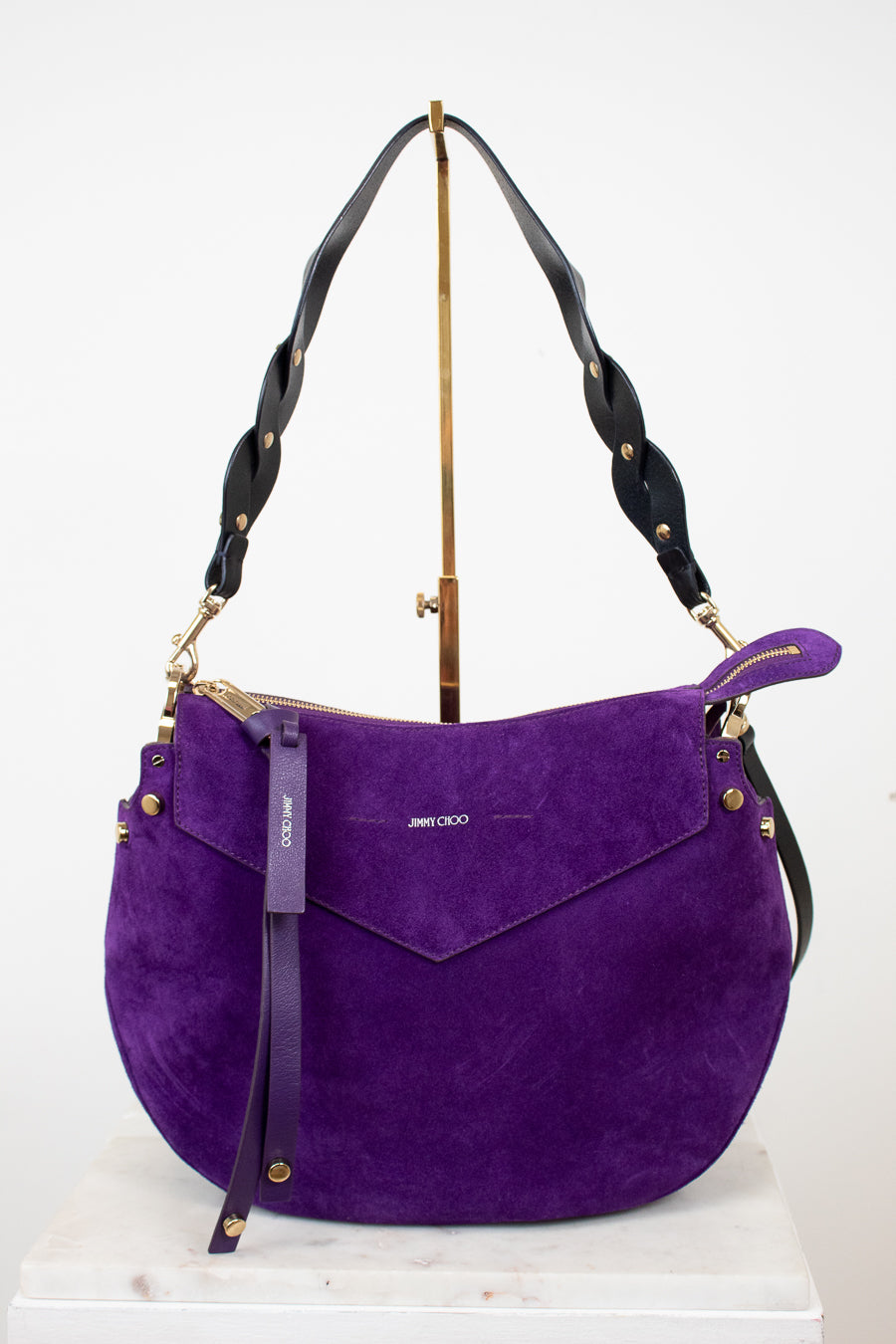 Purple handbag with black strap on a white background